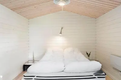 a room with a bed with white pillows at BL1718-Blokhus-Ronliensvej-16 in Blokhus