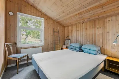 a bedroom with a large bed and a window at BL1627-Blokhus-Lyngvej-17 in Blokhus