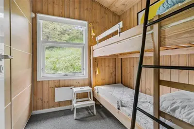 a bedroom with two bunk beds and a window at BL1627-Blokhus-Lyngvej-17 in Blokhus