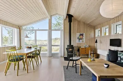 a living room with a table and chairs and a fireplace at BL809-Pandrup-Lommelaerken-20 in Pandrup