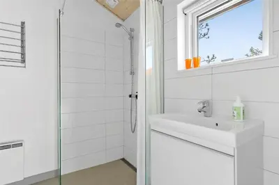 a white bathroom with a sink and a shower at BL809-Pandrup-Lommelaerken-20 in Pandrup