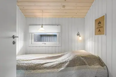 a bedroom with a bed in a room with a window at BL1739-Blokhus-Bag-Hojen-47 in Blokhus