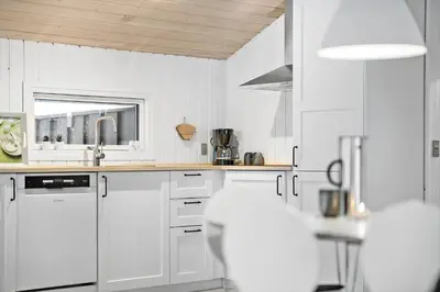 a white kitchen with white cabinets and a sink at BL1739-Blokhus-Bag-Hojen-47 in Blokhus