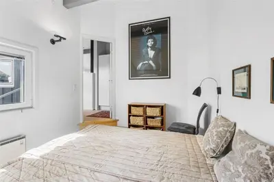 a bedroom with a bed and a poster on the wall at BL1555-Blokhus-Egebaeksvej-17 in Blokhus