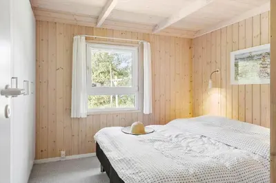 a bedroom with a bed with a hat on it at BL1304-Blokhus-Bag-Hojen-45 in Blokhus