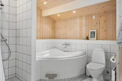 a bathroom with a tub and a toilet and a sink at BL1304-Blokhus-Bag-Hojen-45 in Blokhus