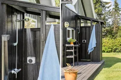 a black shed with a blue towel on the door at BL935-Blokhus-Tobaksvej-1 in Blokhus
