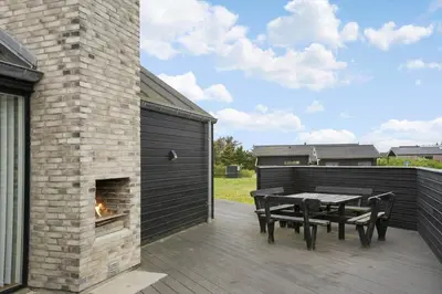 a patio with a table and a fireplace at BL234-Blokhus-Sdr-Strandvej-9-A in Blokhus