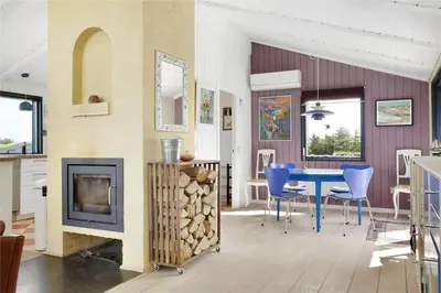 a living room with a table and a fireplace at BL441-Pandrup-Sydvej-14 in Pandrup