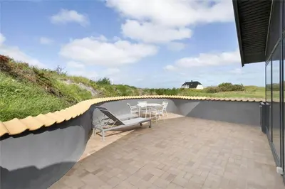 a patio with a table and chairs on a wall at BL441-Pandrup-Sydvej-14 in Pandrup