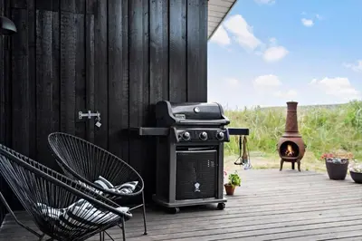 a stove and a chair on a deck with a grill at BL1773-Saltum-Egernvej-6 in Saltum