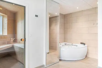 a large bathroom with a tub and a shower at BL1367-Blokhus-Saetergaardsstien-12 in Blokhus