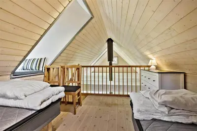 a attic bedroom with two beds and a balcony at BL238-Pandrup-Fyrregangen-18 in Pandrup