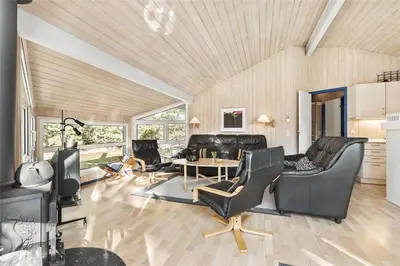 a living room with leather chairs and a table at BL1186-Blokhus-Morten-Nielsensvej-84 in Blokhus