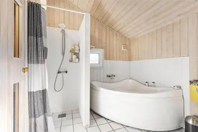 a bathroom with a white tub and a shower at BL1186-Blokhus-Morten-Nielsensvej-84 in Blokhus