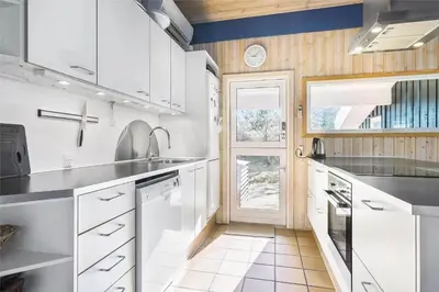 a kitchen with white cabinets and a sink and a door at BL1720-Saltum-Kvansletten-27 in Saltum