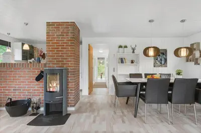 a kitchen and dining room with a fireplace and a dining table at BL1487-Saltum-Brune-Banke-7 in Saltum