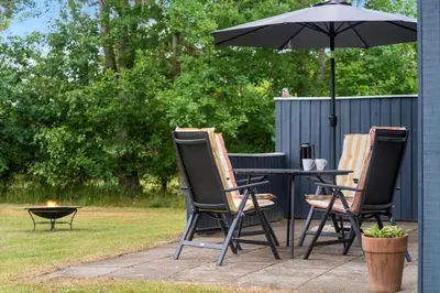 three chairs and a table with an umbrella at BL1487-Saltum-Brune-Banke-7 in Saltum