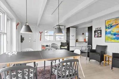 a dining room and kitchen with a table and chairs at BL1455-Blokhus-Pirupshvarrekrogen-6 in Blokhus
