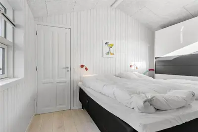 a bedroom with a large bed with white sheets at BL1455-Blokhus-Pirupshvarrekrogen-6 in Blokhus
