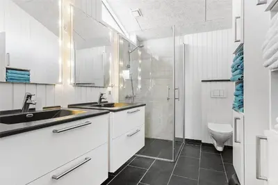 a white bathroom with a sink and a toilet at BL1455-Blokhus-Pirupshvarrekrogen-6 in Blokhus