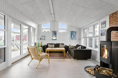 a living room with a couch and a fireplace at BL1455-Blokhus-Pirupshvarrekrogen-6 in Blokhus
