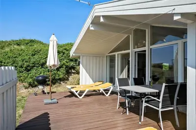 a patio with a table and chairs and an umbrella at BL317-Saltum-Kalundborgvej-1 in Saltum