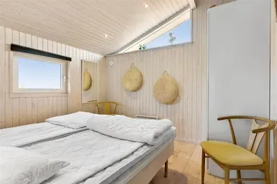a bedroom with a bed and a window and a chair at BL317-Saltum-Kalundborgvej-1 in Saltum