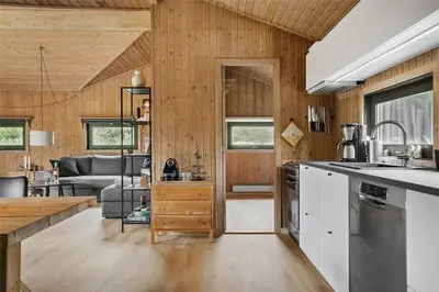 a kitchen and living room with wood paneling at BL1714-Saltum-Lyngsletten-11 in Saltum