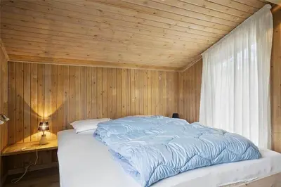 a bedroom with a bed with a wooden ceiling at BL1714-Saltum-Lyngsletten-11 in Saltum