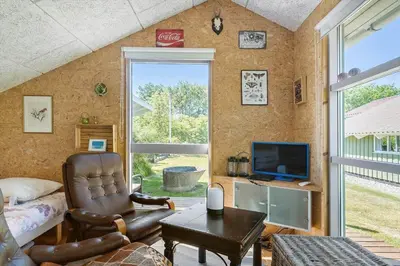 a living room with a leather chair and a television at BL1374-Saltum-Sydvestpassagen-8 in Saltum