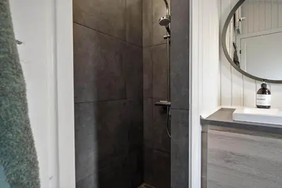 a bathroom with a shower with a sink and a mirror at BL1530-Saltum-Kohlsvej-7 in Saltum