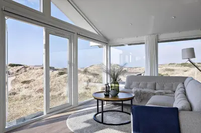 a living room with a couch and a table and windows at BL1530-Saltum-Kohlsvej-7 in Saltum