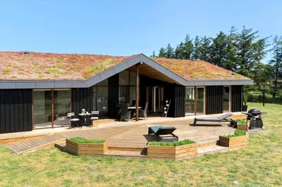 a house with a large wooden deck in front of it at BL1491-Saltum-Laustvej-10 in Saltum