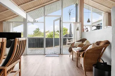 a living room with large windows and a table and chairs at BL177-Saltum-Kvansletten-23 in Saltum