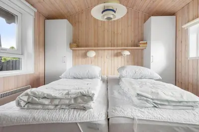 two beds in a room with wooden walls at BL177-Saltum-Kvansletten-23 in Saltum