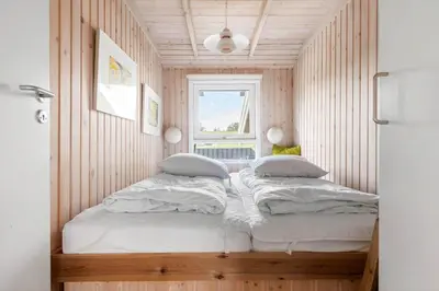 two beds in a small room with a window at BL177-Saltum-Kvansletten-23 in Saltum