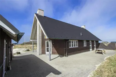 a house with a large patio in front of it at BL1357-Blokhus-Ved-Stranden-2 in Blokhus