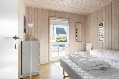 a bedroom with two beds and a window at BL1357-Blokhus-Ved-Stranden-2 in Blokhus