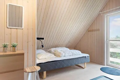 a bedroom with a bed in the corner of a room at BL381-Blokhus-Maxvej-4 in Blokhus