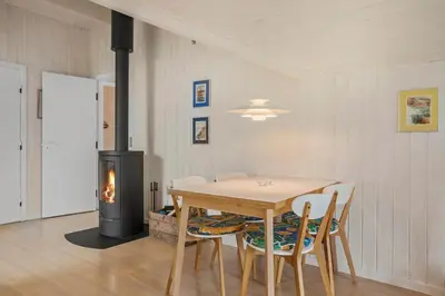 a dining room with a table and a wood stove at BL1558-Saltum-Opossumvej-20 in Saltum