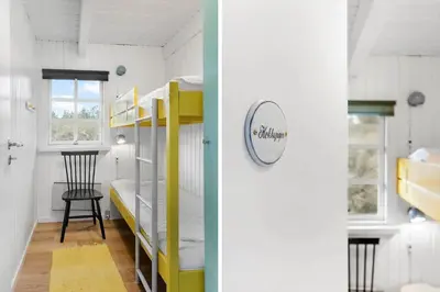 two bunk beds in a small room with a chair at BL1330-Blokhus-Risen-3 in Blokhus
