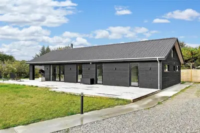 a small black house with a large driveway at BL1442-Blokhus-Bag-Hojen-43 in Blokhus