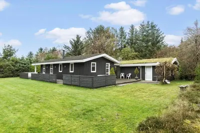 a black house with a large yard in front of it at BL1213-Pandrup-Rodhusparken-14 in Pandrup