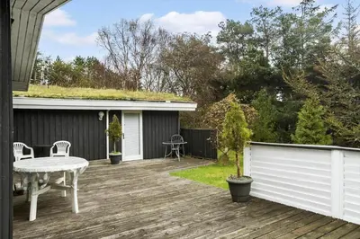 a wooden deck with a table and a fence at BL1213-Pandrup-Rodhusparken-14 in Pandrup