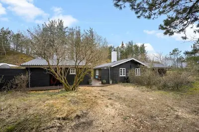 a house with a tree in front of it at BL554-Blokhus-Kragebak-2 in Blokhus