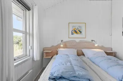a bedroom with two beds sitting next to a window at BL362-Blokhus-Klitvejen-42 in Blokhus