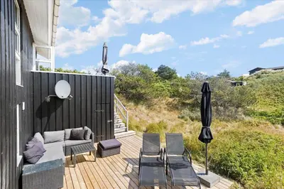 a patio with a couch and chairs on a deck at BL362-Blokhus-Klitvejen-42 in Blokhus