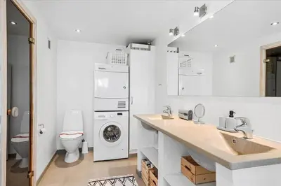 a bathroom with a sink and a washing machine at BL362-Blokhus-Klitvejen-42 in Blokhus