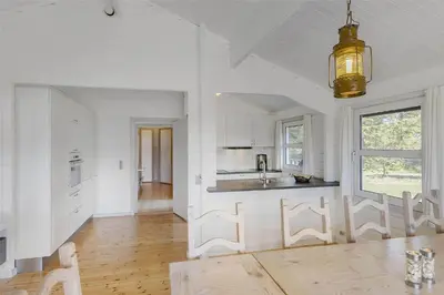 a kitchen with white walls and a wooden floor at BL464-Blokhus-Blaabaerskraenten-8 in Blokhus